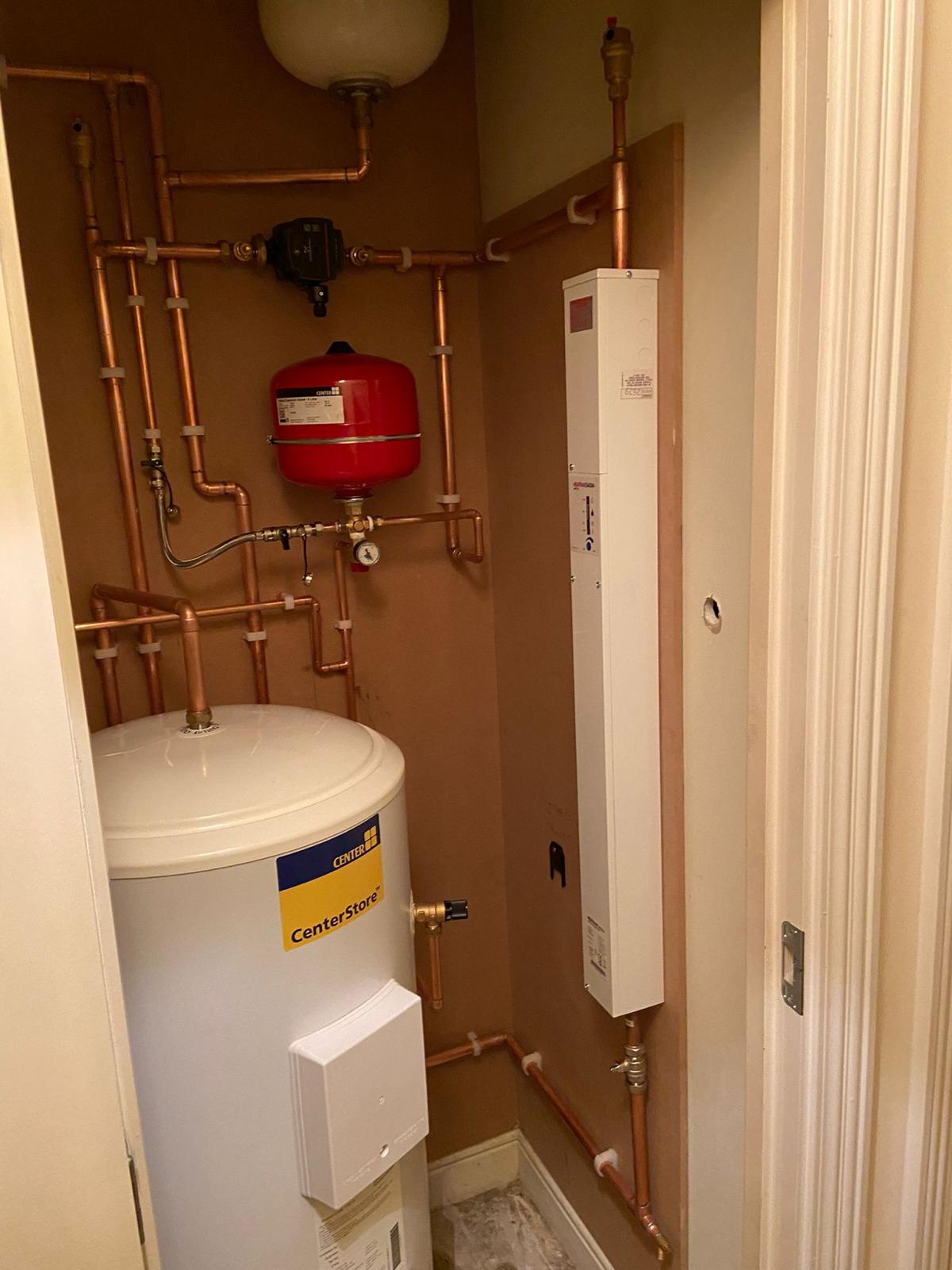 Cylinder installation with copper pipework, expansion vessel and adjacent boiler