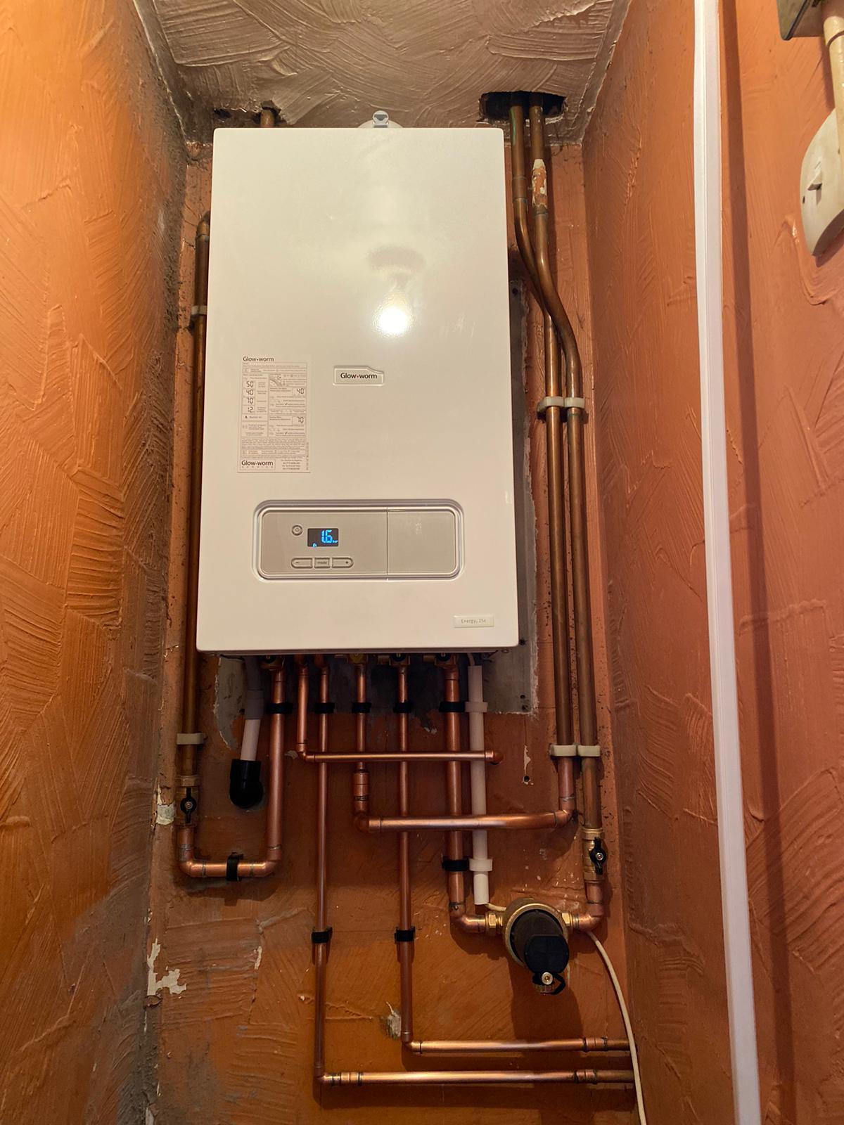 Glow-worm boiler in an alcove with arranged copper pipework and a system filter