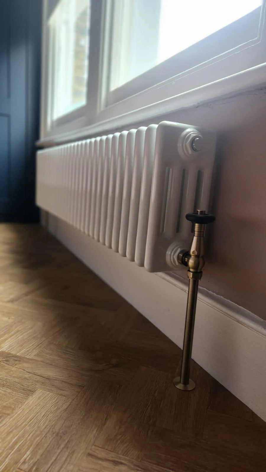 Star Boilers column radiator installation with a brass valve and timber flooring